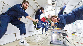 Tyler Krebs and Paul Meuser holding a Yale pennant while on G-Force One (Photo by Steve Boxall, ZERO-G)