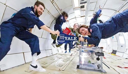 Tyler Krebs and Paul Meuser holding a Yale pennant while on G-Force One (Photo by Steve Boxall, ZERO-G)